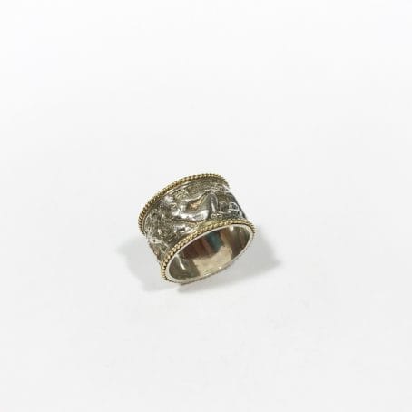 silver band ring with figures in relief