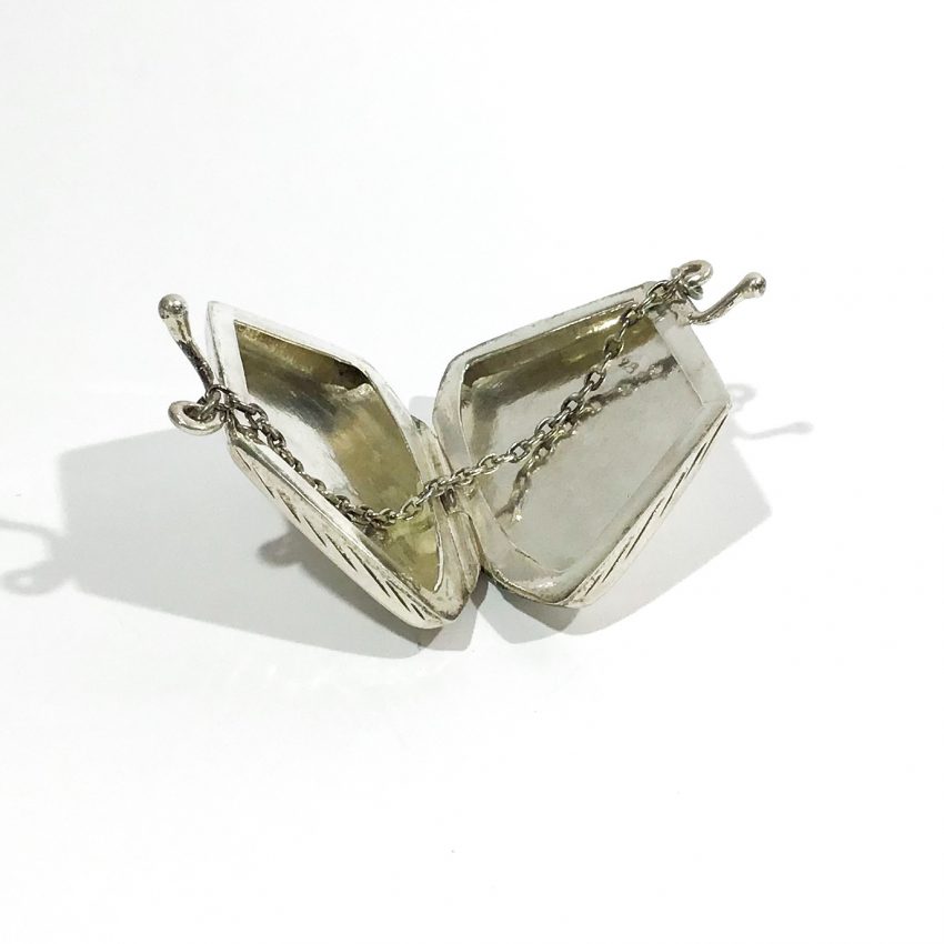 portapillole vintage d’argento a forma di borsetta aperto