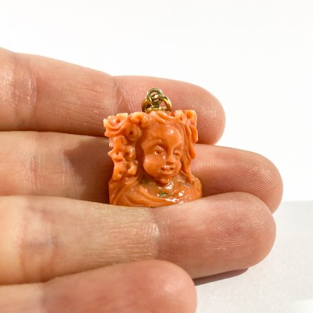 Woman's face pendant in coral